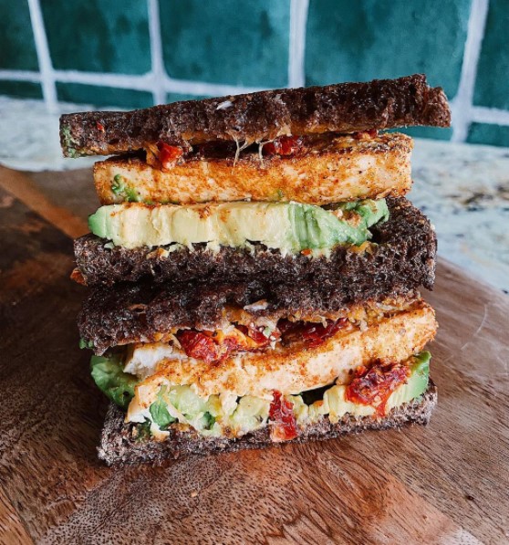 Coating tofu with nutritional yeast to create a vegetable-packed sandwich