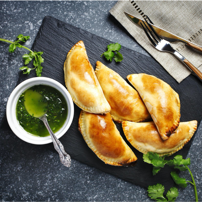 Cheesy eggs, bacon, and vegetables are fried inside a puff pastry shell for a convenient handheld breakfast empanada.