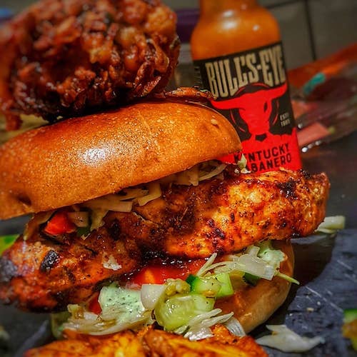A take on an Indian-style burger: Chicken tikka, onion salad, mint sauce, hot sauce with a homemade onion bhaji on top.