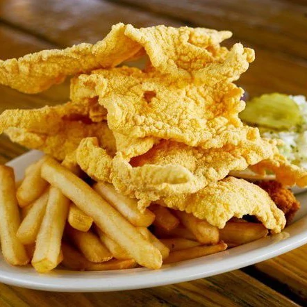 This thin-cut, Cajun-spiced fried catfish offers a unique Louisiana eating experience.