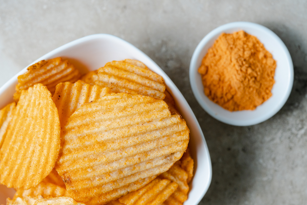 Potato chips with a small bowl of seasoning powder