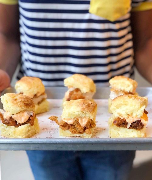 A tray of fried chicken biscuits topped with melty pimento cheese