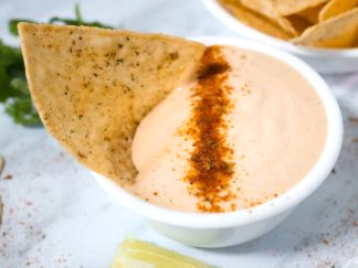 Spicy vegan queso made from raw cashews and Griffith Foods' spicy simulated cheese seasoning adjunct.
