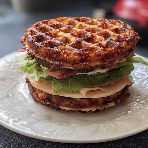 Turkey club sandwich on a waffle made from cheese and eggs for a low-carb sandwich.
