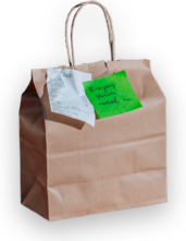 A bag of takeout food with a green note that says enjoy