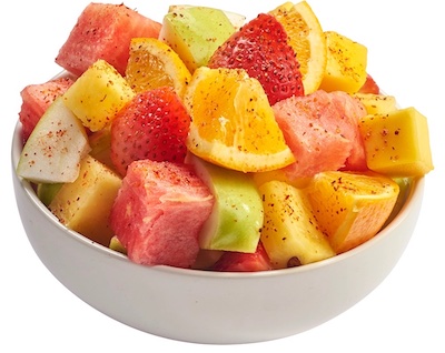 Fruit bowl sprinkled with Tajin seasoning.