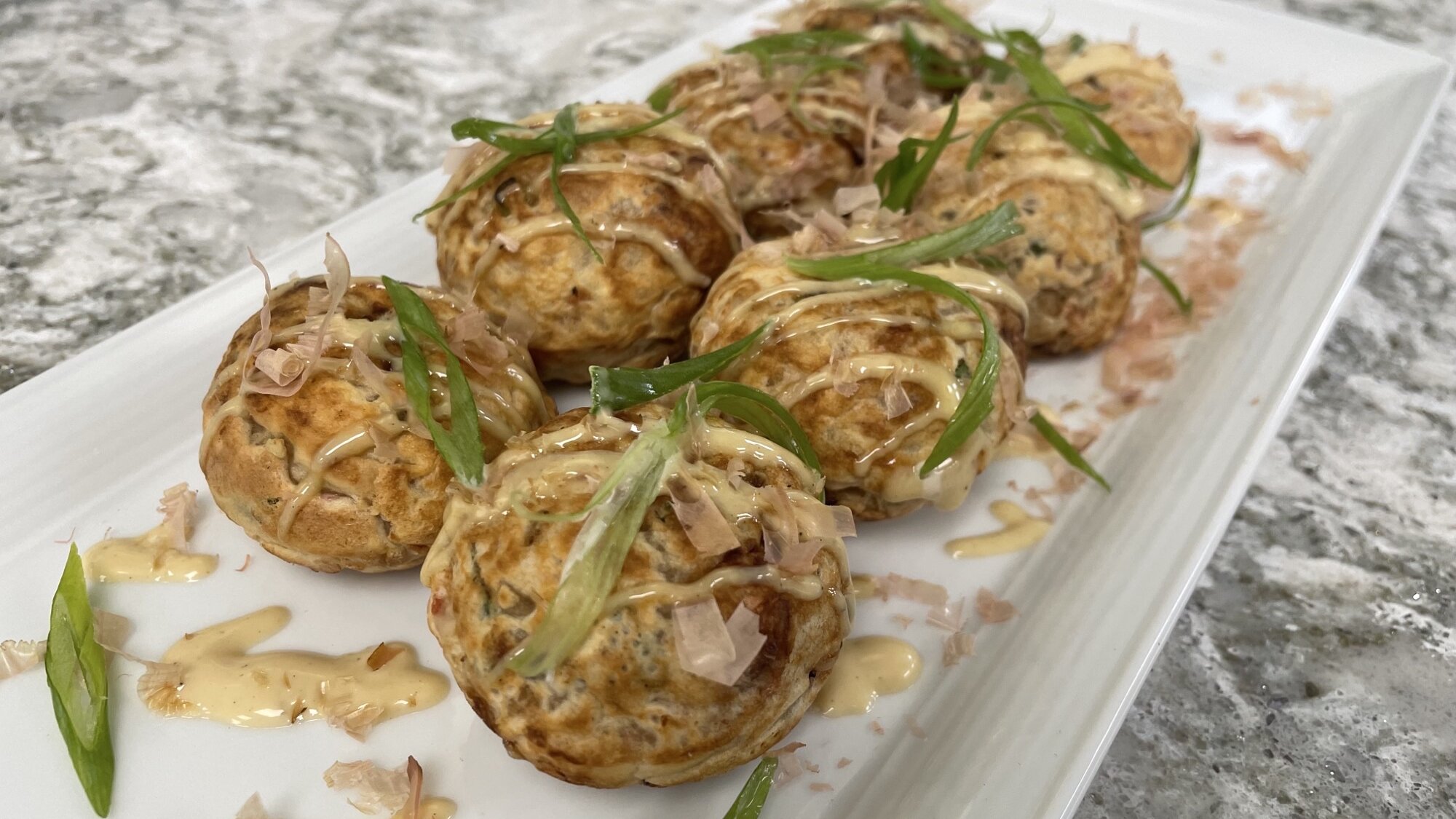 A platter of takoyaki, a traditional Japanese street food made with octopus.