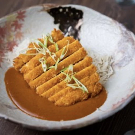 Tonkatsu-style fried pork with a golden curry sauce and a side of white rice.