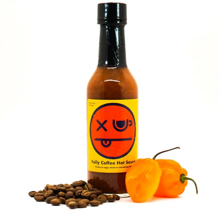 bottle of Folly Coffee Hot Sauce with coffee beans and peppers