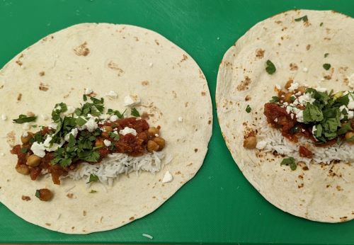 open tortilla with shakshuka breakfast burrito filling on top