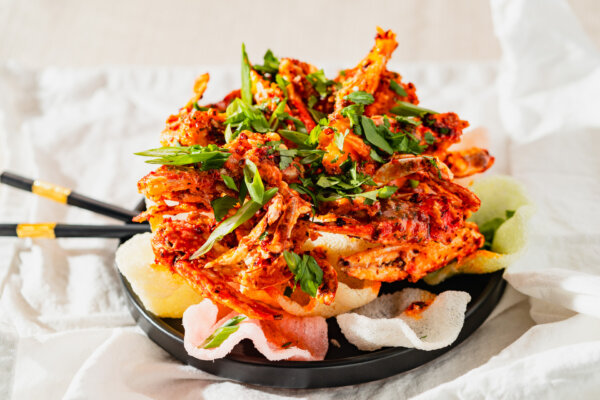Vibrant chili crab curry topped with flash-fried shrimp krupuk and fresh herbs, resting on a bed of colorful prawn crackers – showcasing international seasonings like red pepper, paprika, and coriander in a bold fusion of South American and Asian spice profiles.
